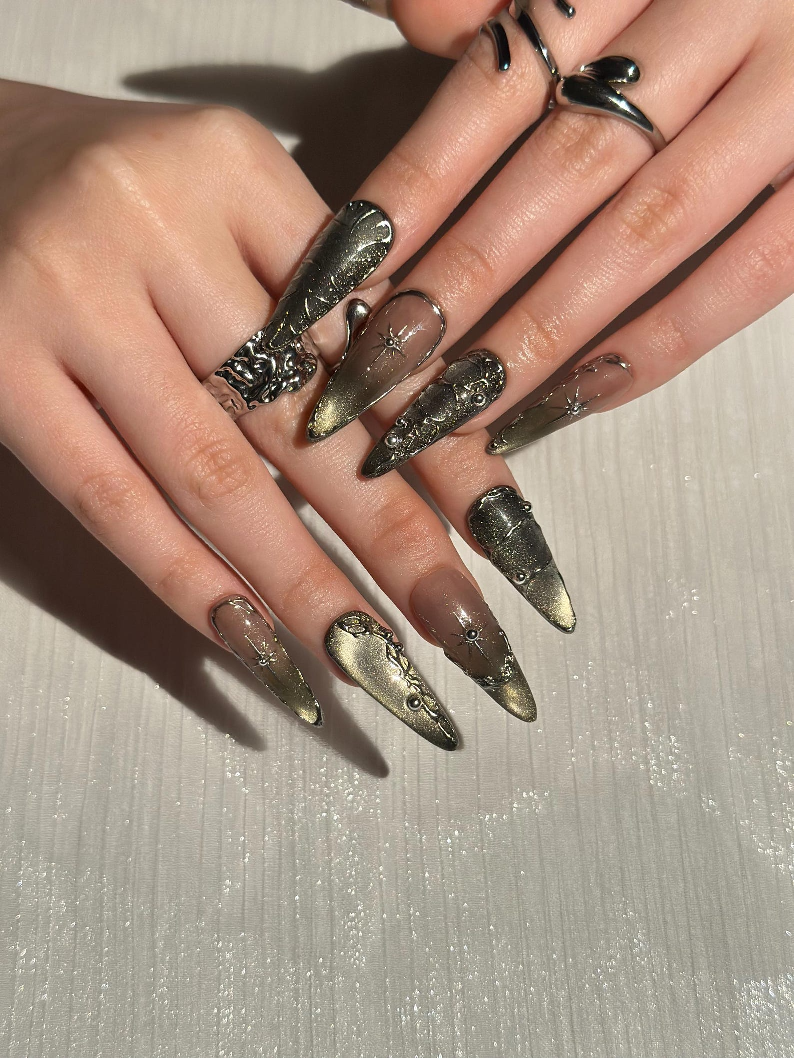 Gothic Celestial Press On Nails. Dark Cat Eye Galaxy Nails with Silver Stars. Edgy Ethereal Stiletto Nails with Metallic Charms. OC1289HC